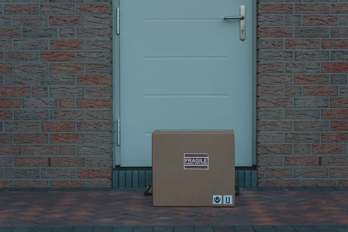 A cardboard delivery package on a doorstep in daylight